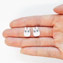 Load image into Gallery viewer, A close up of a hand in front of a white background facing up. Two, small rabbit shaped objects rest in the middle of a finger.
