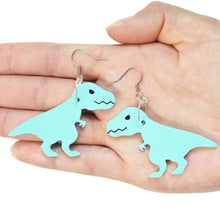 Load image into Gallery viewer, A close up of two T rex earrings lying in the palm of a hand in front of a white background. The T rex are mint coloured and mirror images of each other, hanging from silver coloured hypoallergenic earring hooks.
