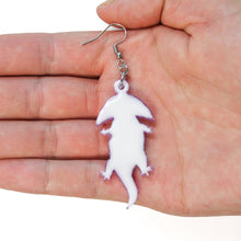 Load image into Gallery viewer, A close up of an earring from the back. It&#39;s based on an animal which is an extinct amphibian that looks like a salamander with a boomerang shaped head. The earring is made from acrylic, but from this view only the white resin backing is visible. The earring is hanging from a silver-coloured stainless steel hook. It&#39;s in a hand facing up in front of a white background.

