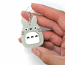 Load image into Gallery viewer, A close up of a hand holding an acrylic earring. The largest part is an acrylic charm of an animal resembling an owl and a rabbit in grey with a white belly, whiskers and round cartoon eyes with a grey body.
