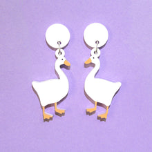Load image into Gallery viewer, A pair of white goose earrings on a purple background.
