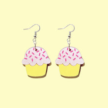 Load image into Gallery viewer, A pair of cute cupcake earrings with silver coloured hooks in front of a pale yellow background. The cupcakes have a yellow base, baby pink icing and hot pink sprinkles.
