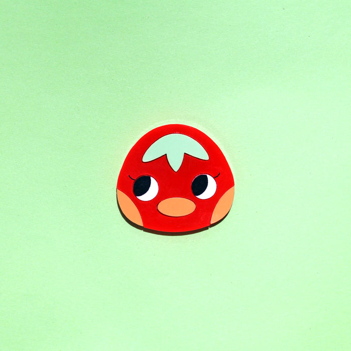 Cute Ketchup! An acrylic plastic brooch of a cartoon duck that resembles a tomato with red face, round cartoon eyes, green tuft of hair that resembles a leaf, orange blushing cheeks and an orange bill.