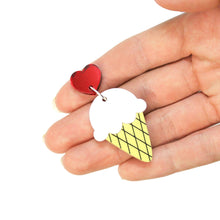 Load image into Gallery viewer, A cute acrylic ice cream earring lying on a hand, facing upwards in front of a white background. The ice cream earring is of a single scoop of vanilla nested atop a pastel yellow wafer cone, hanging from a silvertone ring from a deep red heart.
