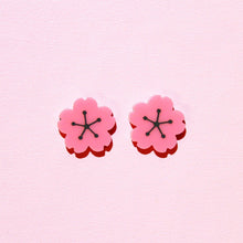 Load image into Gallery viewer, A pair of pink, plastic cherry blossom earrings in front of a pale pink background.
